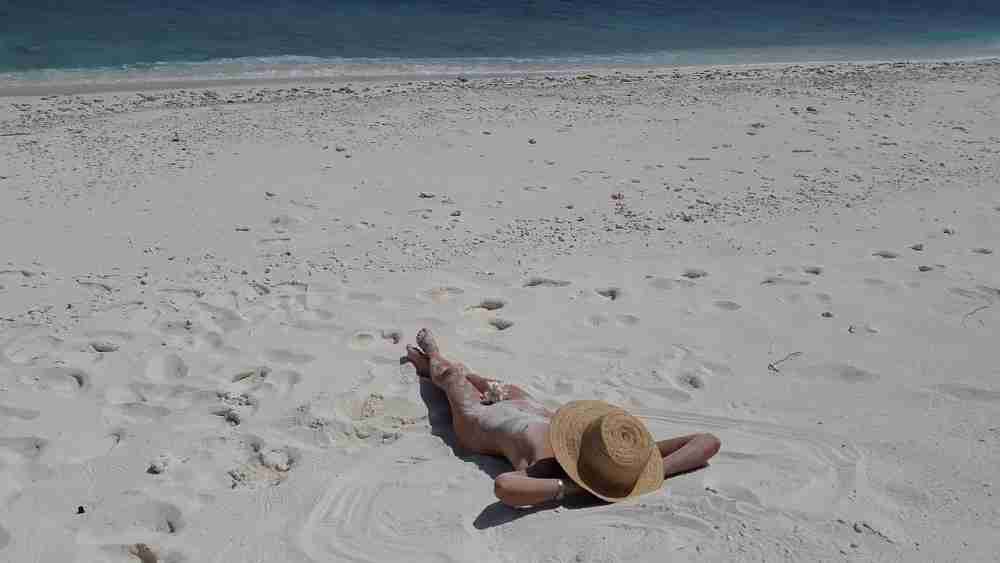 FKK Strand Szene mit nackter Person in natürlicher Umgebung, ohne Identifizierbarkeit